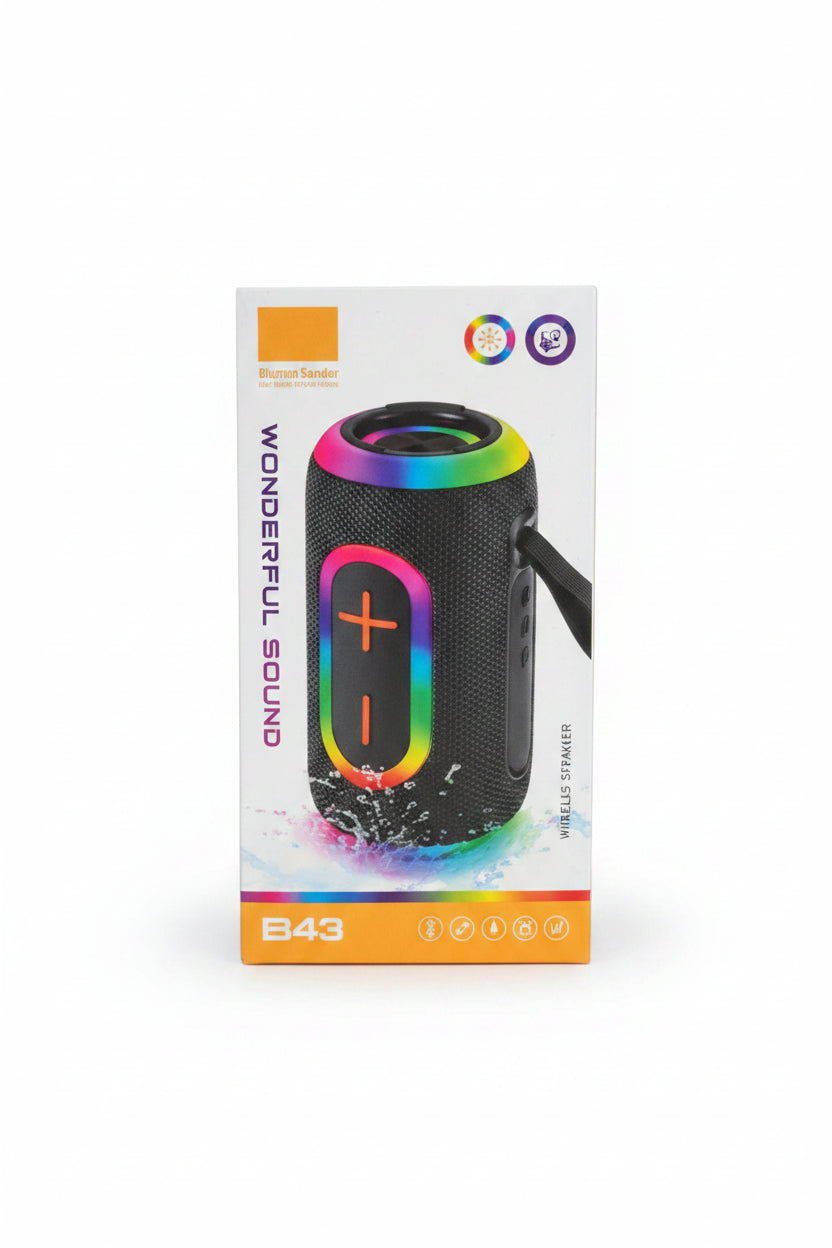 A hand holding a box of a portable Bluetooth speaker in a retail store setting. The packaging shows a black cylindrical speaker with a glowing multicolor LED ring and the text ''.